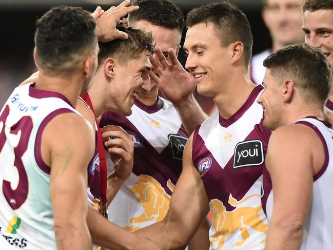 GOLD COAST, AUSTRALIA - APRIL 24: Zac Bailey of the Lions celebrates with team mates after receiving the Ashcroft medal during the round six AFL match between the Gold Coast Suns and the Brisbane Lions at Metricon Stadium on April 24, 2022 in Gold Coast, Australia. (Photo by Matt Roberts/AFL Photos/Getty Images)