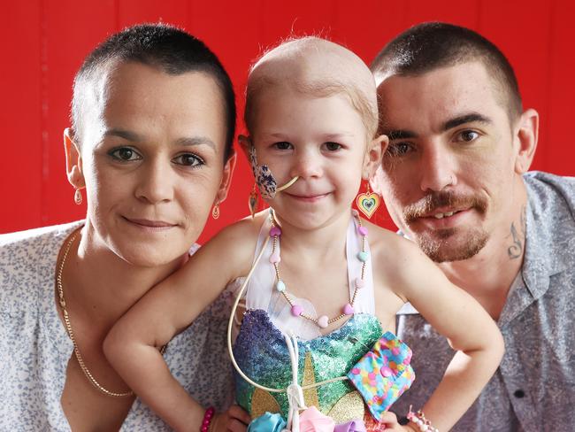 Stevee and Terry Kennedy with shaved heads with their daughter Emerara, 3, who is fighting neuroblastoma, East Brisbane. Picture: Liam Kidston