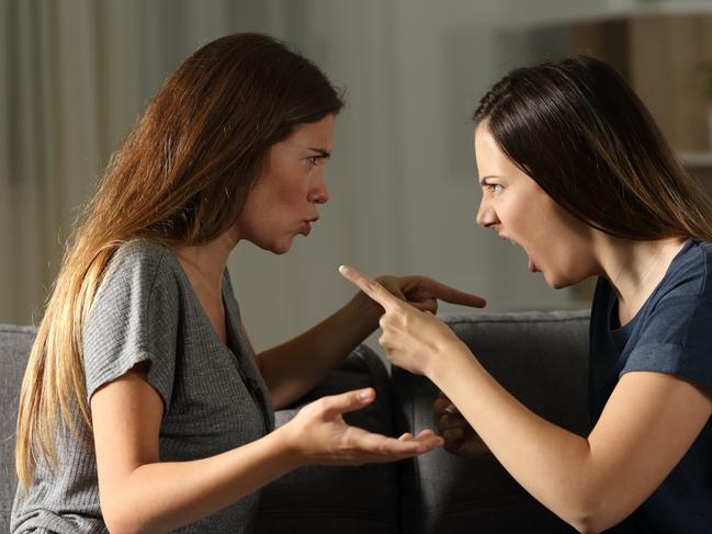 Side view portrait of two friends arguing and shouting in the night at home; ; family fight argument generic