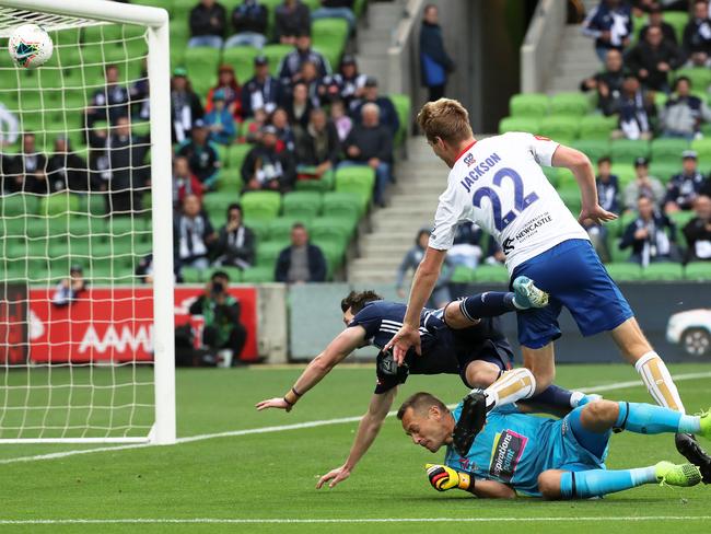 Robbie Kruse of Melbourne Victory scores as he crashÕs into Glen Moss and Lachlan Jackson of Newcastle Jets during the Round 13 A-League match between Melbourne Victory and Newcastle Jets at AAMI Park in Melbourne, Sunday, January 5, 2020. (AAP Image/George Salpigtidis) NO ARCHIVING, EDITORIAL USE ONLY