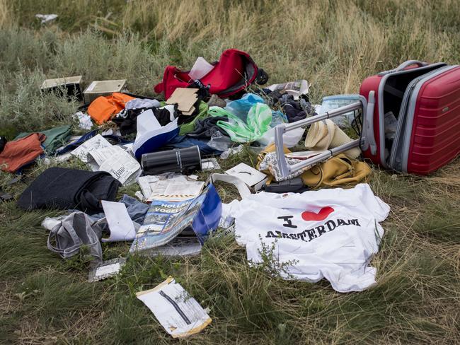 Luggage and personal belongings from Malaysia Airlines flight MH17 lie in a field, all 298 on board including 80 children died in the crash. Picture: Rob Stothard/Getty Images