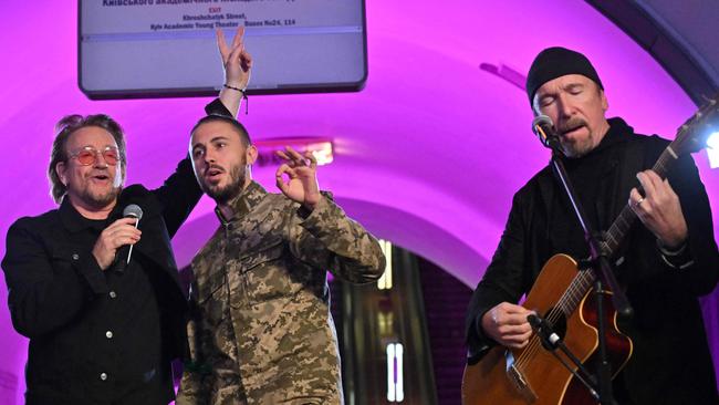 US singer Bono, left, guitarist The Edge, right, and Antytila, a Ukrainian musical band leader and now the serviceman in the Ukrainian Army, perform at subway station in Kyiv. Picture: AFP