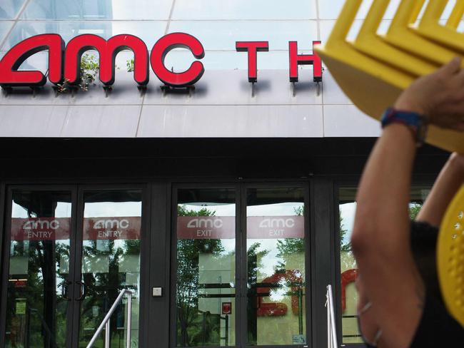 A worker moves a stack of chairs outside of the AMC Georgetown 14 Theatres in Washington, DC on June 3, 2021. - A day after its share price almost doubled, AMC Entertainment on June 3 successfully completed a large new equity offering despite warning prospective shareholders that they could potentially lose their entire investment. (Photo by MANDEL NGAN / AFP)