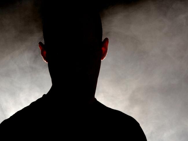 Silhouetted figure emerges from a smoky background.