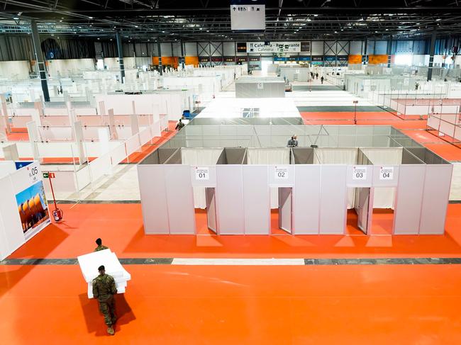 Workers and soldiers working in a temporary hospital set-up for coronavirus infected patients at the pavilion 9 of the Ifema convention and exhibition centre in Madrid. Picture: AFP