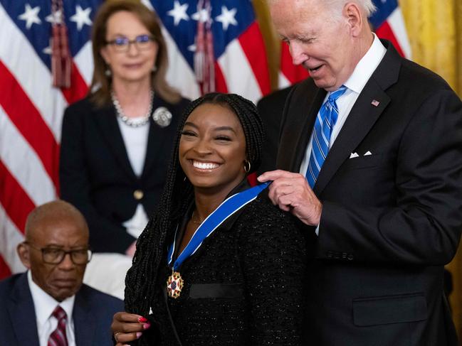 US President Joe Biden presents Gymnast Simone Biles with the Presidential Medal of Freedom, the nation's highest civilian honor, during a ceremony honoring 17 recipients, in the East Room of the White House in Washington, DC, July 7, 2022. (Photo by SAUL LOEB / AFP)