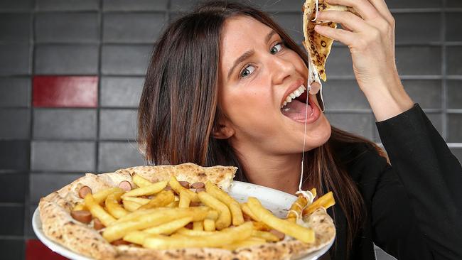 Cassandra Kowalik tucks into the pizza with chips at 400 Gradi in Brunswick. Picture: Ian Currie