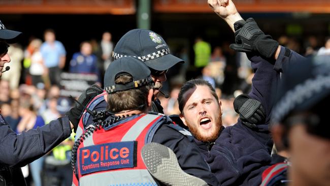 Police move to remove vegan protesters who blocked the intersection of Flinders and Swanston Street in Melbourne during widespread vegan protests. Picture: Andrew Henshaw/News Corp Australia