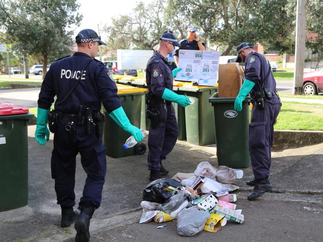 Detectives from Eastern Beaches Local Area Command and the State Crime Command’s Homicide Squad sift through rubbish bins in Maroubra.
