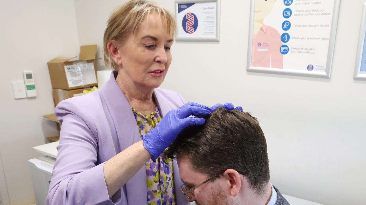 Ros Bates Shadow Minister for Health and Ambulance Services medically assisting journalist Andrew Messenger. Picture: Liam Kidston.