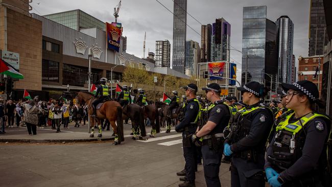 Police officers line up in front of mounted police outside the Crown Casino and Convention Centre as demonstrators protest in Melbourne on Sunday. Picture: NewsWire / Tamati Smith.