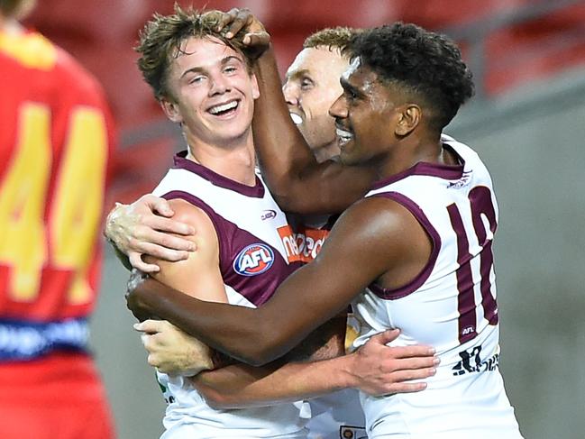 GOLD COAST, AUSTRALIA - MARCH 08: Harry Sharp of the Lions celebrates kicking a goal with team mates during the AFL Community Series match between the Gold Coast Suns and the Brisbane Lions at Metricon Stadium on March 08, 2021 in Gold Coast, Australia. (Photo by Matt Roberts/AFL Photos/via Getty Images)