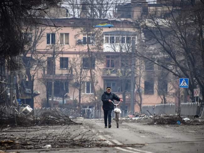 A man walks with a bicycle in downtown Mariupol. Picture: Alexander Nemenov/AFP