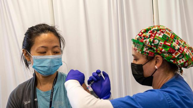 Nurse and Army Veteran Renee Langone administers a Moderna Covid-19 vaccine to US Air Force (active duty reservist) Doctor Pei-Chun McGregor at the West Roxbury VA Medical Center in Boston, Massachusetts. Picture: AFP