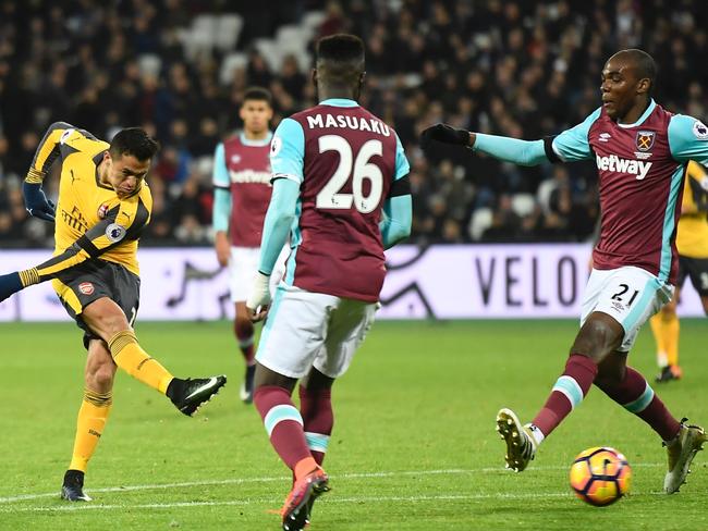 Arsenal's Chilean striker Alexis Sanchez (L) shoots to score their third goal.