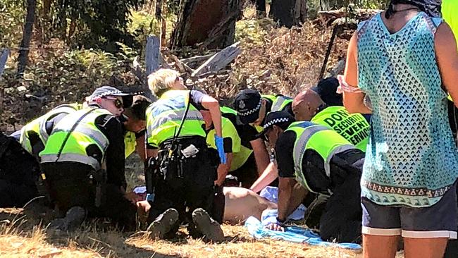 Emergency services attend to a man before he is loaded into an ambulance at the Rainbow Serpent Festival.