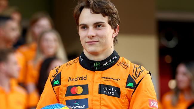 ABU DHABI, UNITED ARAB EMIRATES - DECEMBER 05: Oscar Piastri of Australia and McLaren looks on at the McLaren team photo in the Pitlane during previews ahead of the F1 Grand Prix of Abu Dhabi at Yas Marina Circuit on December 05, 2024 in Abu Dhabi, United Arab Emirates. (Photo by Bryn Lennon - Formula 1/Formula 1 via Getty Images)