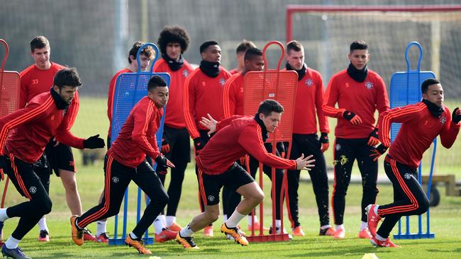 Manchester United players engage in a sprint contest in training.