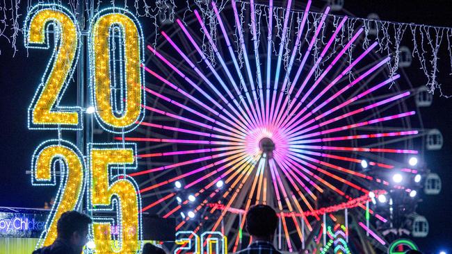 People walk at the Sheikh Zayed Heritage Festival as they await the New Years Eve fireworks and drone show in Abu Dhabi. Picture: AFP