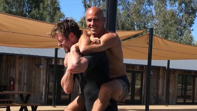 Chris Hemsworth and Kelly Slater playfighting in a photo posted to Hemsworth's Twitter.