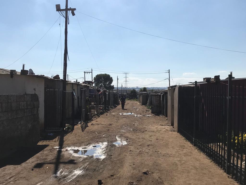 A dirt road lined with shacks in Zone 11.