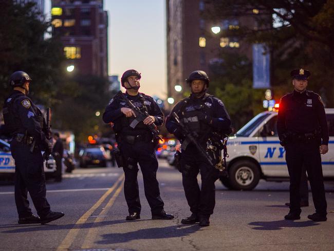 Heavily armed police stand guard near the scene after a motorist drove onto a busy bicycle path near the World Trade Center memorial and struck several people. Picture: AP