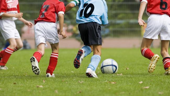 Children playing soccer, with four players in action.