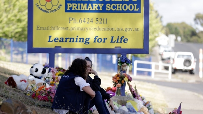 A Lifeline worker speaks with a distraught woman outside the school. Picture: NCA Newswire / Grant Viney