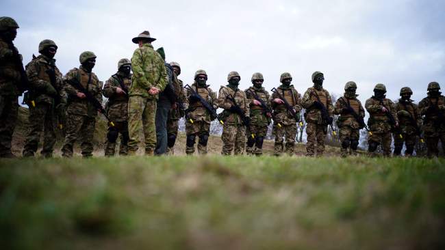 Australian Armed Forces member speaks to Ukrainian soldiers as they take part in a training session. Picture: Ben Birchall/AFP