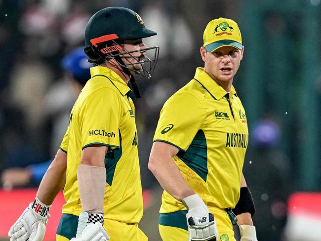 Australia's Travis Head (L) and captain Steve Smith walk back to the pavilion as rain stops play during the ICC Champions Trophy one-day international (ODI) cricket match between Australia and Afghanistan at the Gaddafi Stadium in Lahore on February 28, 2025. (Photo by Aamir QURESHI / AFP)