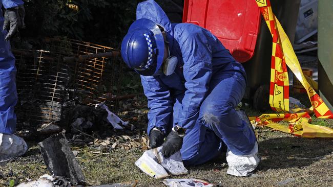 Forensic specialists carried dozens of burnt and wet children’s school work books and colouring books from the home. Picture: Richard Dobson