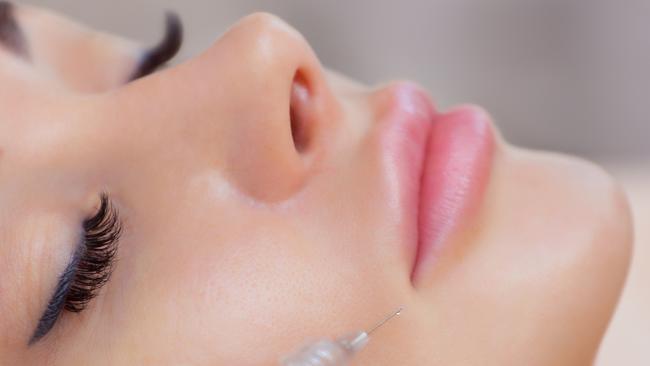 The doctor cosmetologist makes Lip augmentation procedure of a beautiful woman in a beauty salon.Cosmetology skin care.