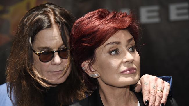 Ozzy Osbourne hiding behind his estranged wife.