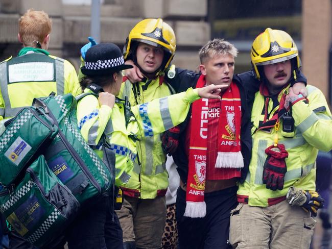 Police and emergency personnel help a man after the shocking incident on Water Street near the Liver Building in Liverpool. Picture: Owen Humphreys/PA via AP