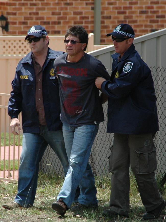 Les Mara is arrested by Australian Federal Police officers.