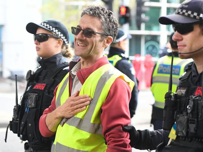 An activists from Extinction Rebellion is arrested during a protest in Melbourne, Thursday, October 10, 2019. The Extinction Rebellion climate protests movement has planned a "spring rebellion" from Monday to Sunday, including marches aimed at blocking traffic. (AAP Image/Erik Anderson) NO ARCHIVING