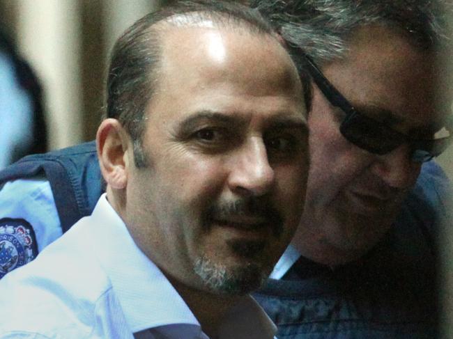 Supreme Court. Tony Mokbel looks up with a grin as he arrives alone in a prison van (with support van with armed guards one with a shotgun, standing by as he was unloaded)