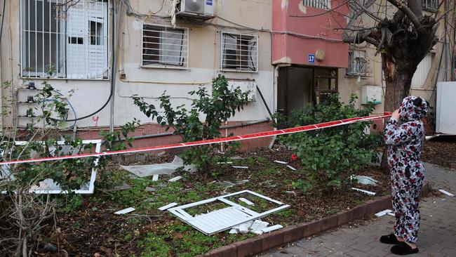 A woman inspects the damage as she evacuates her home in Tel Aviv in December after a projectile fired from Yemen landed near her building. Picture: AFP