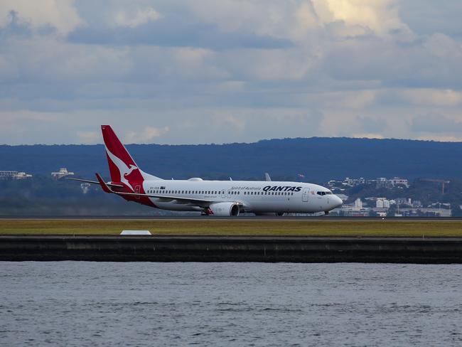 SYDNEY, AUSTRALIA - NewsWire Photos JUNE 14, 2021: A view of a Qantas plane landing at Sydney Domestic Airport from Port Botany in Sydney Australia. Picture: NCA NewsWire / Gaye Gerard