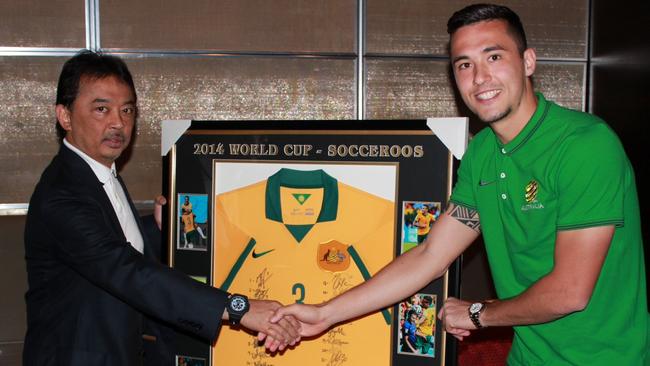 Jason Davidson presents Prince Abdullah with a signed Socceroos jersey.