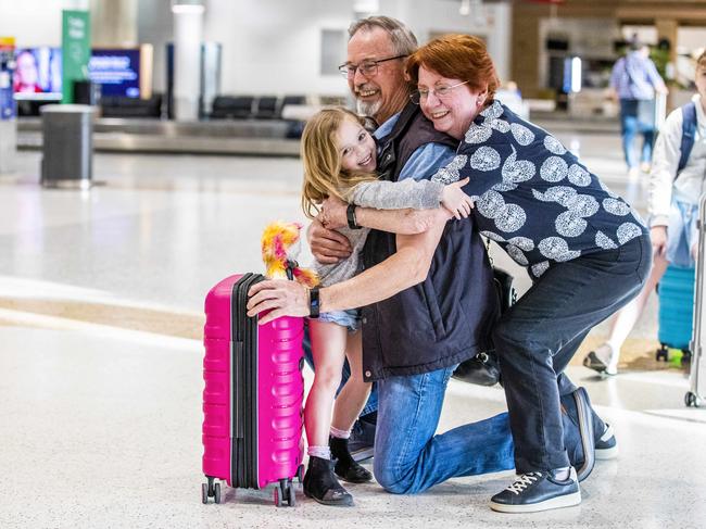 Robert and Susan Forster of Priestdale grab hold of their five-year-old granddaughter Poppy Brecknock after she flew in to Brisbane from Sydney. Picture: Richard Walker