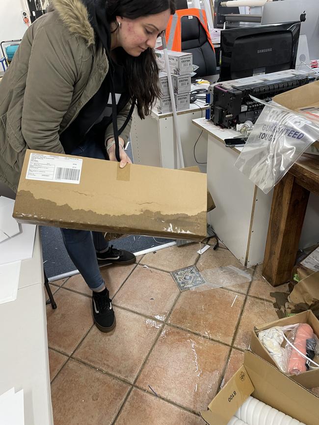 Angela Darwich, manager at Kwik Kopy Milperra, discovers more flood damage as she walks through the store. Picture: Paul Brescia