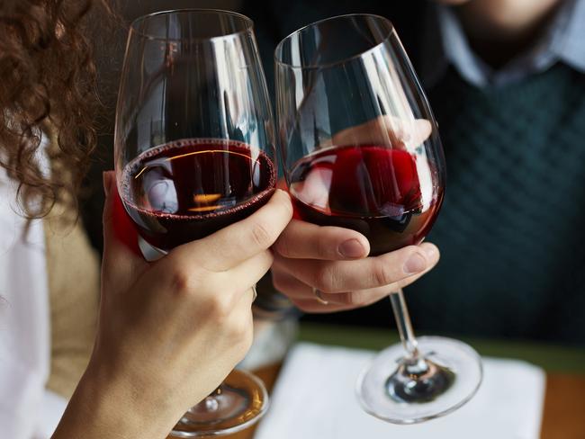 Amorous couple toasting with red wine in restaurant