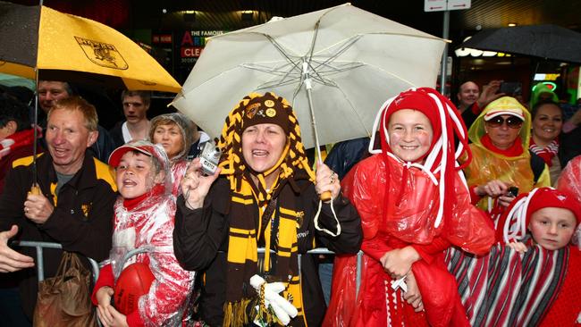 Supporters for Hawthorn and Sydney crowd the wet streets of Melbourne for the 2012 AFL Grand Final parade.