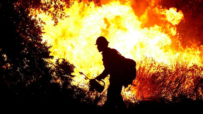 A U.S. Forest Service firefighter uses a drip torch to light a back fire in La Crescenta, California, USA 31 Aug 2009. The out of control Station Fire has burned more than 105,000 acres and has forced thousands of evacuations as nearly 12,000 homes are threatened. (Justin Sullivan/Getty Images/AFP) FOR NEWSPAPERS, INTERNET, TELCOS & TELEVISION USE ONLY.