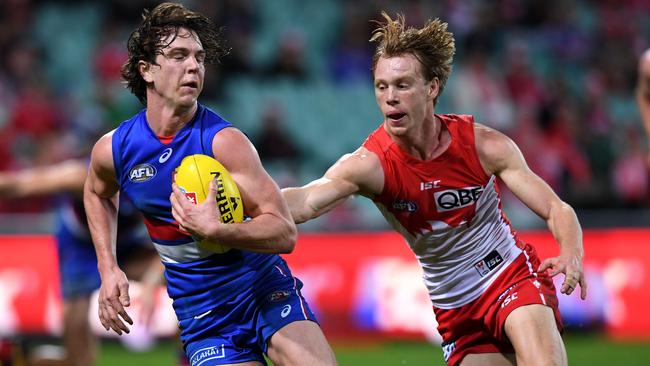 Liam Picken tries to slip out of a tackle by Callum Mills.