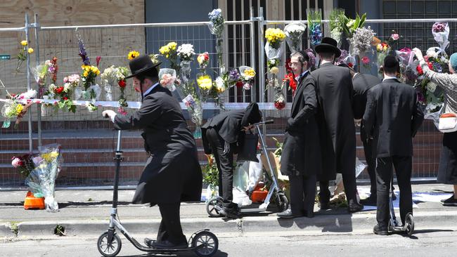 People lay flowers outside the Adass Israel Synagogue. Picture: David Crosling