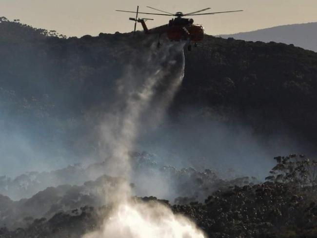 Firefighters are working to slow the spread of fire in Jamison Valley while aerial firefighters like ‘Gypsy Lady’ (pictured at Narrowneck) continue picking up water from Wentworth Falls Lakes to water bomb affected areas. Photo: Christopher Indyka.