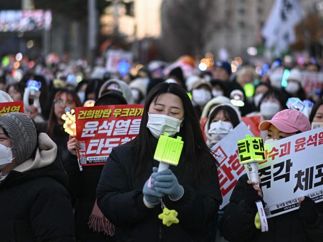 People sing along K-pop music during a protest calling for the ouster of South Korea's President Yoon Suk Yeol outside the National Assembly in Seoul on December 8. Picture: Philip Fong/AFP