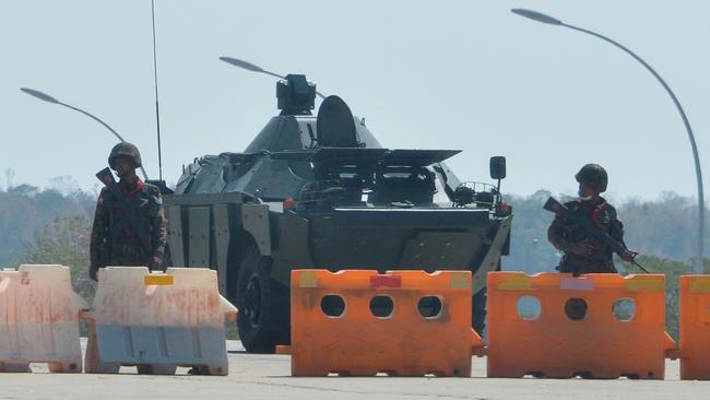 Soldiers stand guard on a blockaded road to Myanmar's parliament in Naypyidaw on Monday. Picture: AFP